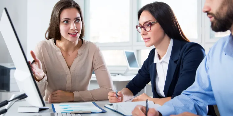 Equipo de consultoras analizando procesos frente a una computadora