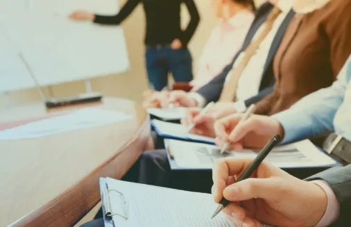 Participantes tomando notas durante una capacitación